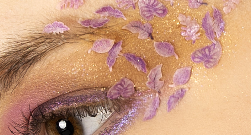 Roze en paarse blaadjes in wax rond het oog gelegd over glinsterende oogschaduw, feeënlook