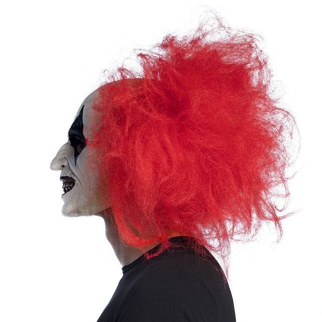 Ruddy clown hoofdmasker van zijkant gedragen, kromme neus en rood haar tot in de nek