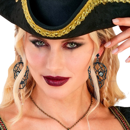 Schedel oorbellen met strass ogen close-up, gedragen bij een zwarte piratenhoed