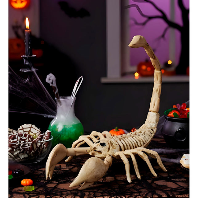 Schorpioen skelet als decoratie op een halloweentafel met pompoenen, spinrag en kaars