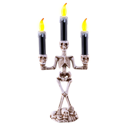 Skelet kandelaar 35 cm van pvc met drie zwarte kaarsen, ledvlammen en doodskoppen voor Halloween