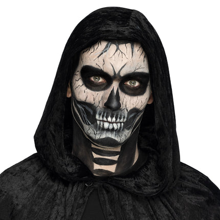 Skeletgezicht geschminkt met de doodskop schminkset, zwarte oogkassen en witte tanden voor Halloween