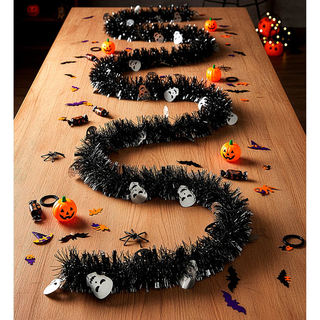 Slinger met schedeltjes in golven over een houten tafel als halloweendecoratie