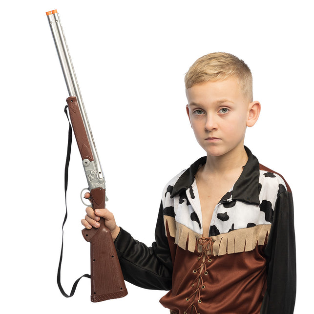 Speelgoedgeweer Ranger in de hand van een jongen in cowboykostuum voor een westernfeest