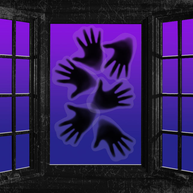 Spook handen stickers op een verlicht raam als halloweendecoratie in het donker