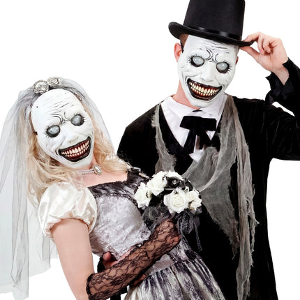 Twee grijnzende monstermaskers met grijze bolle ogen bij een griezelig bruidspaar op Halloween