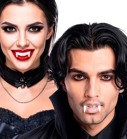 Vampiertanden glow in the dark gedragen door een dame met rode lippen en een heer in zwart, voor Halloween