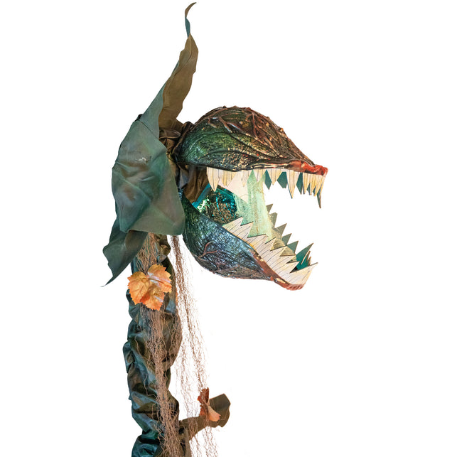 Vleesetende plant animatronic van opzij met wijd open kaak en vezelige slierten aan de stam