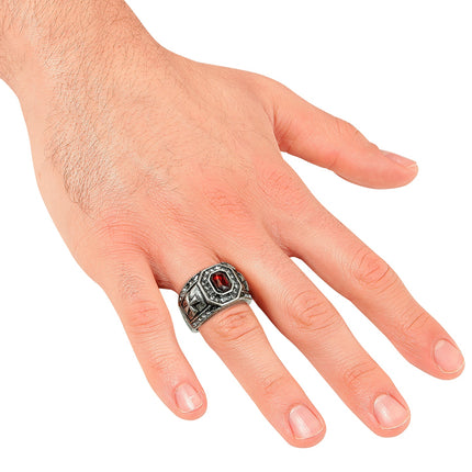 Zegelring met rode steen gedragen aan de vinger van een man, brede band
