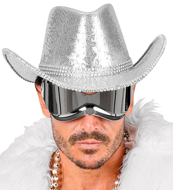 Zilveren pailletten cowboyhoed op het hoofd van een man, ingedeukte bol en gebogen rand