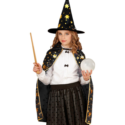 Zwarte tovenaarscape met sterren op meisje, met witte blouse en hoge sterrenhoed voor een kinderfeest
